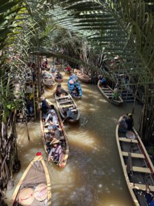 Wooden boat on a peaceful canal surrounded by coconut palms in the Mekong Delta, Vietnam